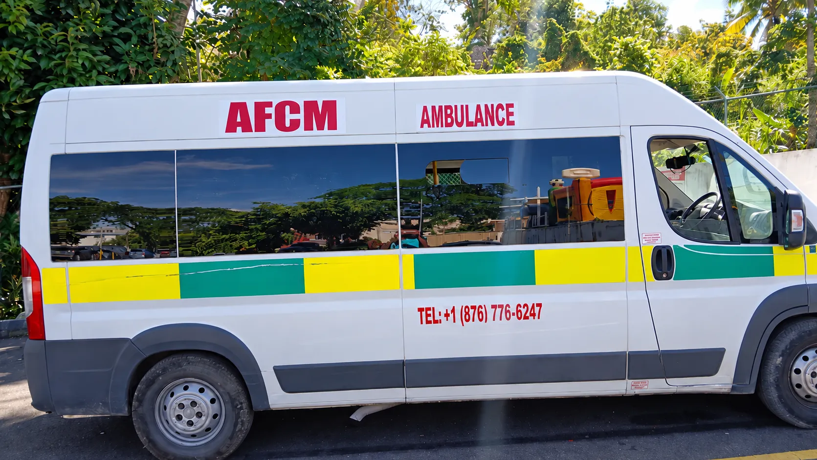Side view of an AFCM ambulance in Jamaica, showing the AFCM name and ambulance markings